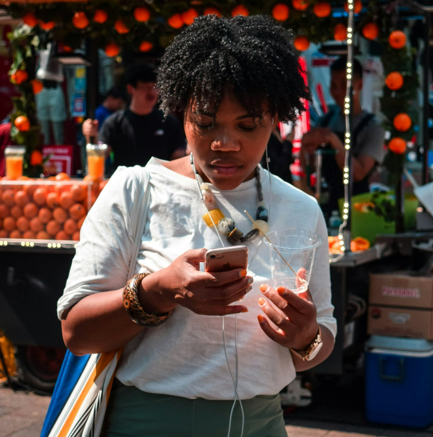 woman in white button up shirt holding clear drinking glass